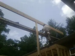 Carpenter setting a ridge beam over a new addition frame — Ice Dam Removal by Roofing Brothers in Circle Pines