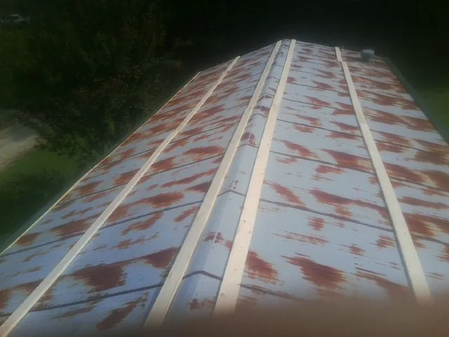 Rusted metal roof panels with new wood purlins before replacement — Storm Damage Roof Repair in Circle Pines by Roofing Brothers