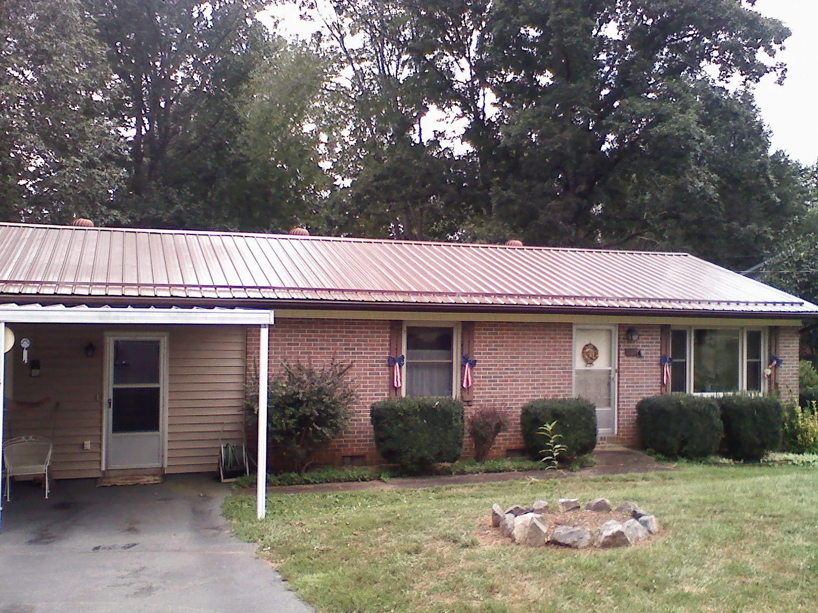 Bronze metal roof and carport on a brick ranch home — Roof Repair work by our crew in Circle Pines